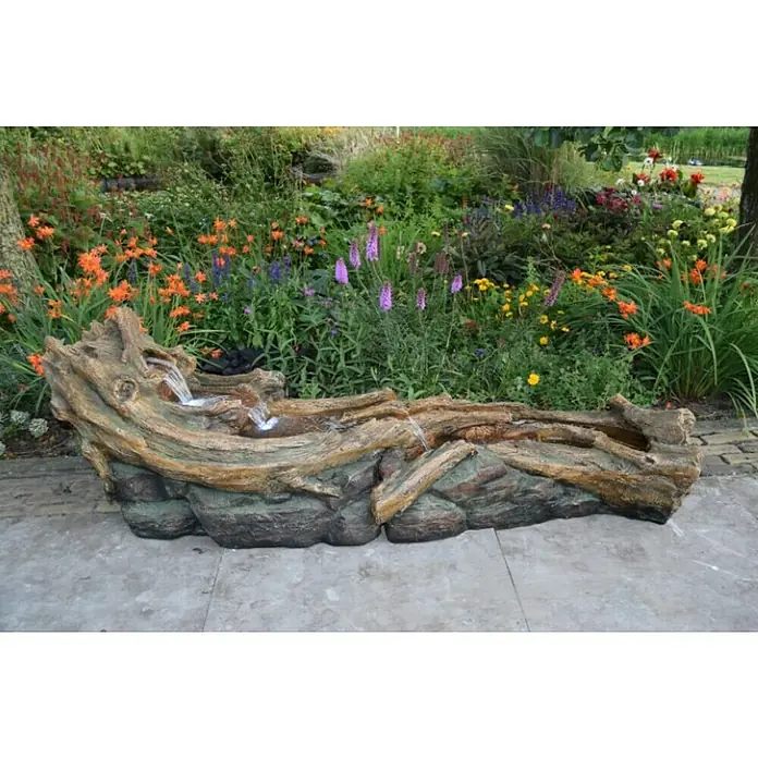 Ubbink AcquaArte Standbrunnen Arbia - 150 x 46 x 48 cm - Eine dekorative Gartenbrunnen-Skulptur in Form eines Baumstamms mit fließendem Wasser vor üppigem Grün.