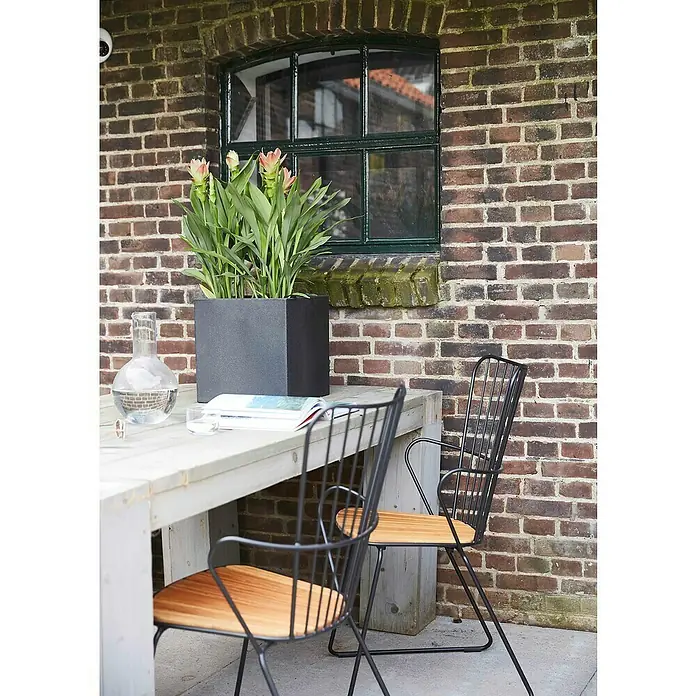 Capi Europe Urban Pflanztopf Smooth - Außenmaß (L x B x H): 30 x 30 x 30 cm, Kunststoff, Schwarz - Eine Nahaufnahme eines stilvollen Außenbereichs mit einem Tisch, Stühlen und einem eleganten Pflanzgefäß mit blühenden Pflanzen.