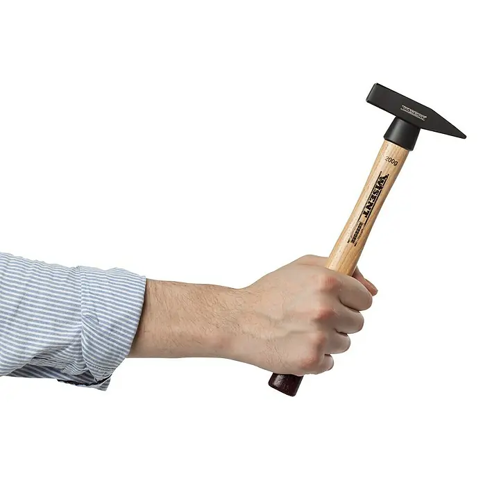 Wisent Martillo de cerrajero - 200 g, Acero, Mango de madera nogal - Primer plano de un martillo de carpintero de la marca Visent con mango de madera sostenido en una mano.