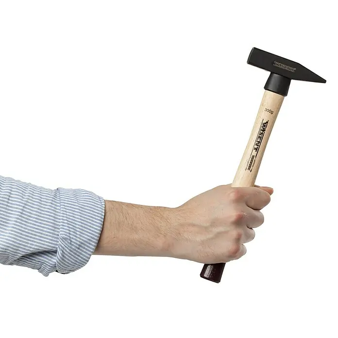 Wisent Martillo de cerrajero - 300 g, Acero, Mango de madera nogal - Primer plano de un martillo de carpintero sujetado por una persona. El martillo tiene un mango de madera y una cabeza negra.