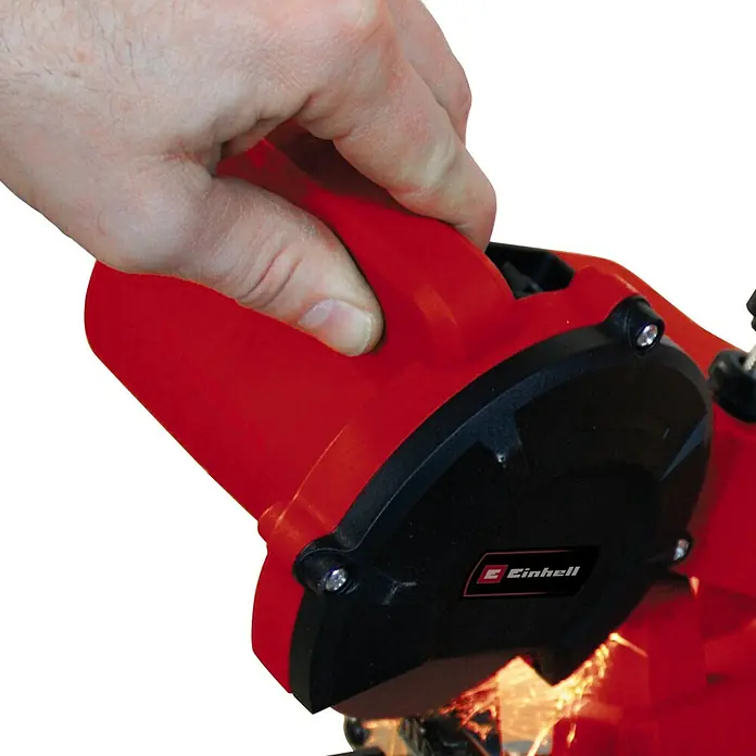 Einhell Sägekettenschärfgerät GC-CS 85 E - Mit Tiefenbegrenzung, Kettenspannvorrichtung, inklusive Schleifscheibe - Eine Hand bedient einen Einhell Kettensägeschärfer mit rotem Gehäuse und schwarzem Schutzdeckel.
