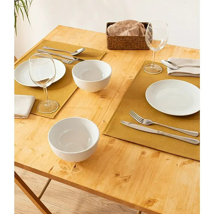 Tisch-Set Monaco Raw - Ocre, 45 x 30 cm - Tischgedeck mit Tellern, Schüsseln, Besteck, Gläsern und Brotkorb auf gelben Tischsets auf einem Holztisch.