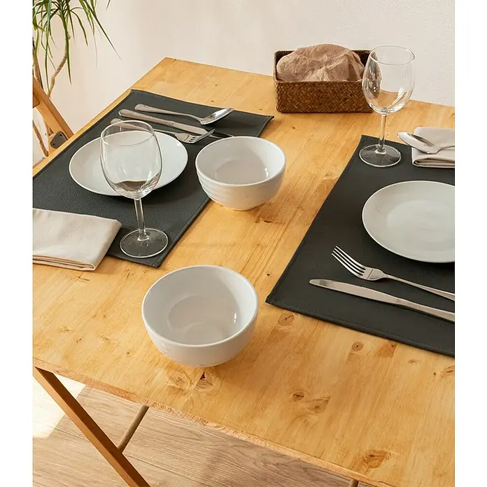 Tisch-Set Monaco - Steel Grey, 45 x 30 cm - Ein gedeckter Esstisch mit Tellern, Schüsseln, Besteck und Gläsern auf grauen Platzsets, die eine elegante und praktische Tischdekoration bieten.
