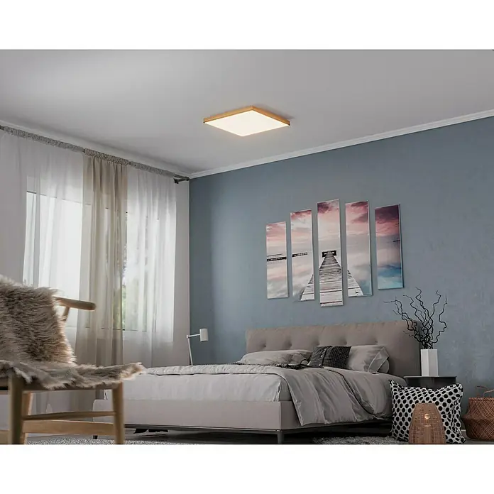 Globo Doro LED-Panel Holzoptik - 36 W, 59 x 59 cm, Holzoptik/Graphit, Warmweiß - Ein quadratischer LED-Deckenleuchte mit Holzrahmen spendet warmes Licht in einem modern eingerichteten Schlafzimmer mit blau gestrichener Wand.