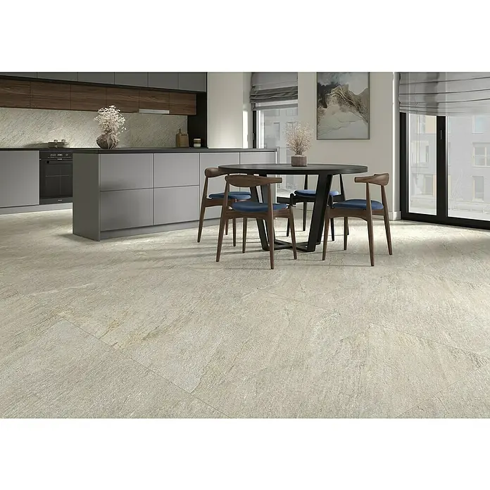 Feinsteinzeugfliese Piazza Sabbia - 59,7 x 59,7 cm, Beige/Grau, Matt - Helle, großformatige Bodenfliesen mit natürlicher Steinoptik verlegen einen modernen Küchen- und Essbereich mit Esstisch und Küchenzeile.