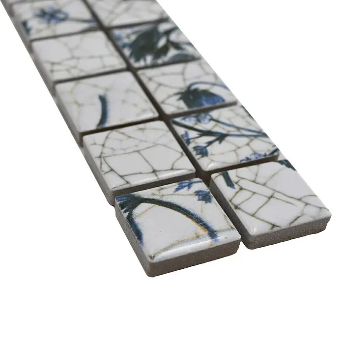 Fliesenbordüre Strawberry YBO BERRY - 29,8 x 4,8 cm, Weiß/Blau, Matt - Ein Band aus Mosaikfliesen mit blau-weißem Blumenmuster, das eine elegante und detailreiche Oberfläche zeigt.