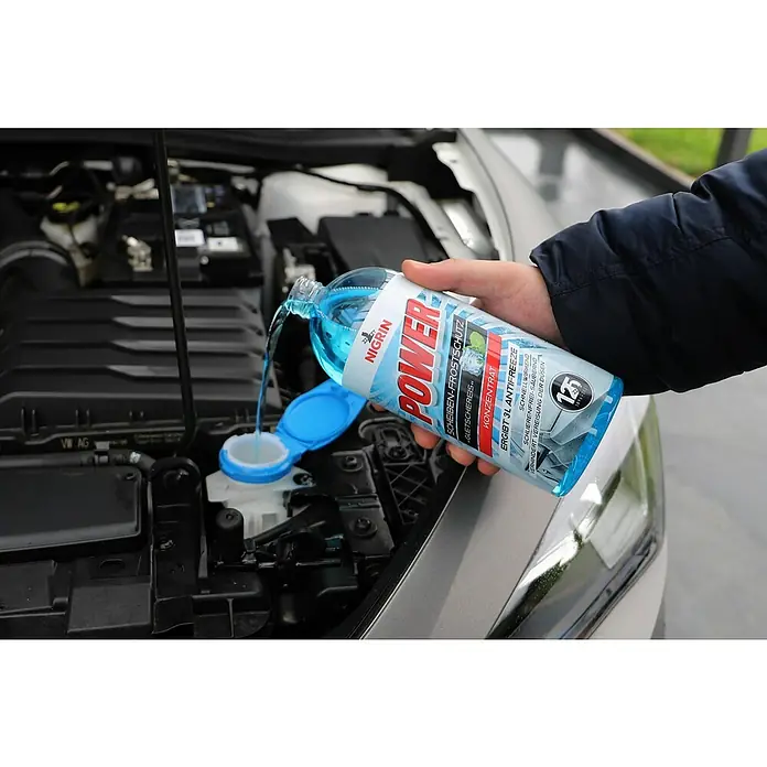 Nigrin Scheibenfrostschutz-Konzentrat - 1 l, Max. Frostbeständigkeit: -52 °C - Eine Hand füllt Scheibenfrostschutz von Nigrin Power in den Behälter eines Autos. Das Produkt bietet zuverlässigen Schutz vor Frost und Eis.