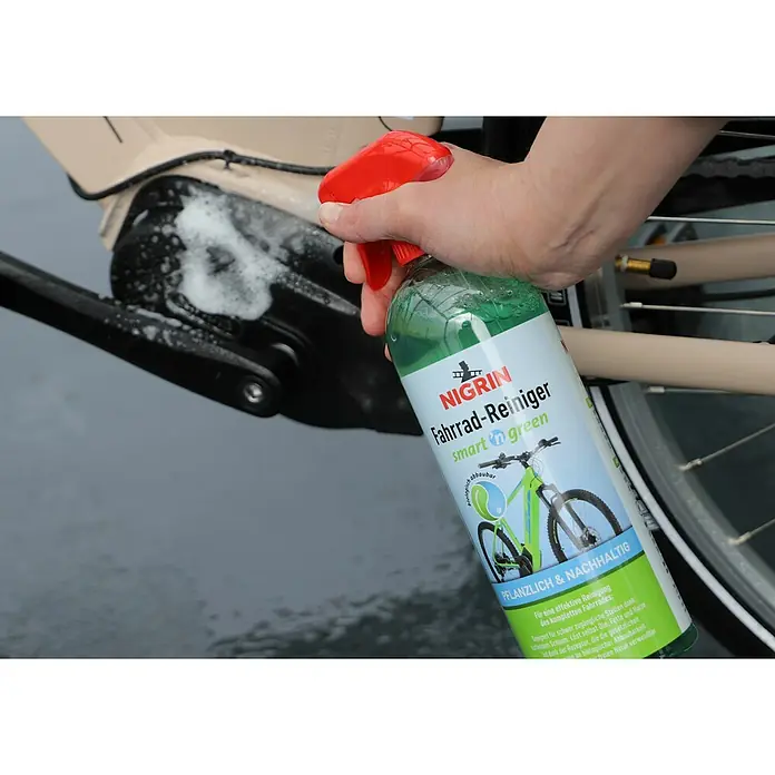 Nigrin Fahrradreiniger SMART'N GREEN - 750 ml - Nahaufnahme einer Person, die mit Nigrin Fahrradreiniger "smart green" ein Fahrrad reinigt.\n