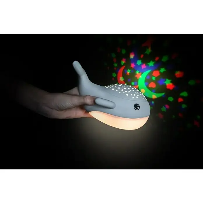 LED-Nachtlicht Wal Willy - L x B x H: 17 x 8,9 x 14 cm, RGBW - Graue Wal-Nachtlampe projiziert bunte Sterne und Monde, gehalten von einer Hand, ideal für Kinderzimmer.