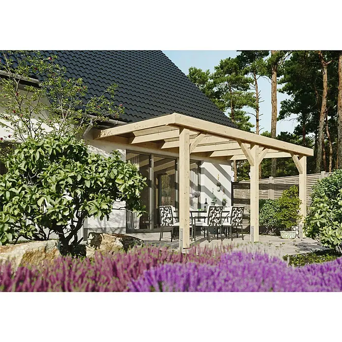 Joda Terrassenüberdachung Natur - B x T: 507 x 314 cm, Natur, Lärche, Dacheindeckung aus Stegplatten - Holzpergola an einem Haus mit Tisch und Stühlen, umgeben von Bäumen und Pflanzen. Die Pergola bietet einen schattigen Platz im Freien.