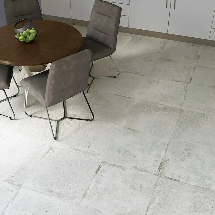 Feinsteinzeugfliese Bond White - 60 x 60 cm, Weiß, Matt - Ein Esstisch mit grauen Stühlen auf einem hellen Fliesenboden, der eine moderne und minimalistische Ästhetik erzeugt.