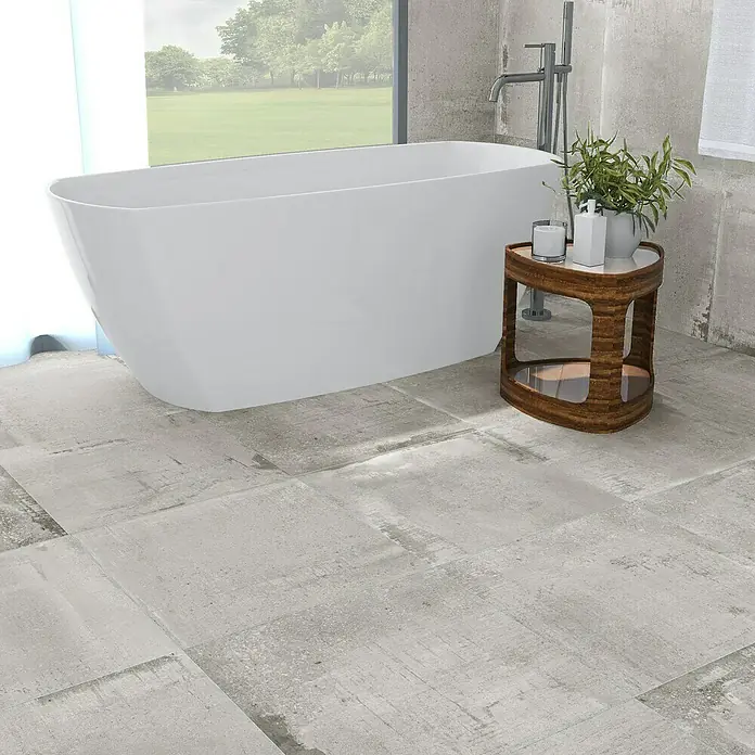 Feinsteinzeugfliese Bond Ash - 60 x 60 cm, Grau, Matt - Geräumiges Badezimmer mit freistehender Badewanne, Holzhocker und grauen Bodenfliesen, die ein modernes und entspannendes Ambiente schaffen.