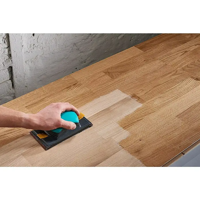 Wolfcraft Schleifpapier - Breite: 115 mm, Körnung: 80 - Nahaufnahme von Schleifarbeiten auf einem Holztisch mit einem Handschleifer, der die Oberfläche glättet und das Holz veredelt.