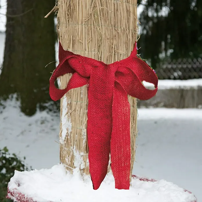 Jutegewebeband - Rot, 25 x 0,1 m - Nahaufnahme eines Strohhalms mit einer hellroten Schleife, der auf einer verschneiten Oberfläche in einer winterlichen Außenumgebung platziert ist.