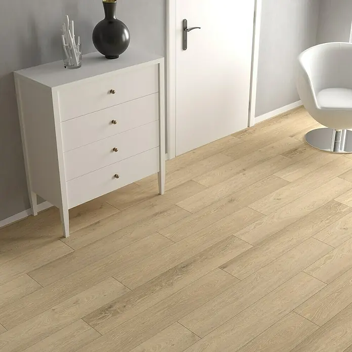 LOGOCLIC Vinylbodenmuster ElementPro Navy Side - 185 x 192 x 4 mm, Landhausdiele - Eine elegante weiße Kommode mit vier Schubladen und goldenen Knöpfen steht auf einem hellen Holzboden, dekoriert mit einer schwarzen Vase und einem Glas.