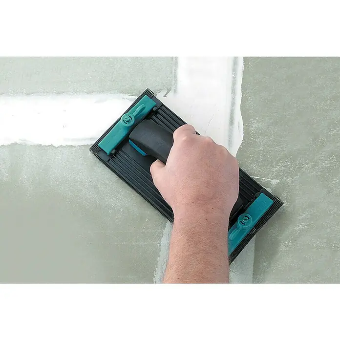 Wolfcraft Schleifgitter-Set - L x B: 280 x 115 mm, 2 Stk. - Eine Person glättet eine verputzte Wand mit einem Handschleifer, um eine ebene Oberfläche zu erzielen. Das Werkzeug ist blau und schwarz.