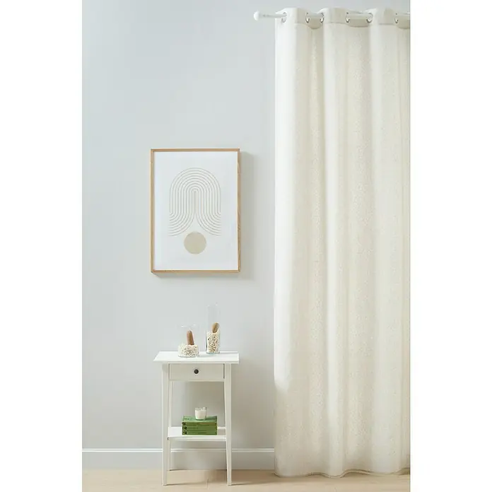 Cortina con ollaos Kruger - An x Al: 140 x 260 cm, Beige/Blanco - Una cortina blanca con ojetes cuelga junto a una impresión enmarcada y una pequeña mesa auxiliar con objetos decorativos, creando un ambiente sereno.