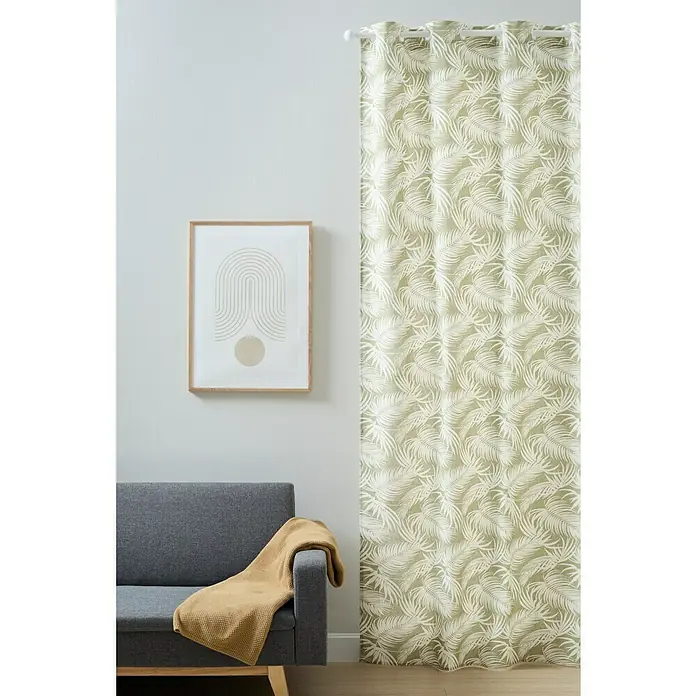 Cortina con ollaos Bergen - An x Al: 140 x 260 cm, Verde, Plástico - Una cortina verde con un estampado de hojas de palma cuelga al lado de un sofá gris con una manta amarilla y un cuadro enmarcado.