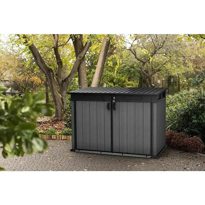 Keter Truhe Cortina Mega - Außenmaß inkl. Dachüberstand (B x T): 191 x 109 cm, Kunststoff, Anthrazit/Schwarz - Eine graue Gartenbox mit Doppeltüren und schwarzem Dach vor einem grünen Garten. Praktische Aufbewahrungslösung für den Außenbereich.