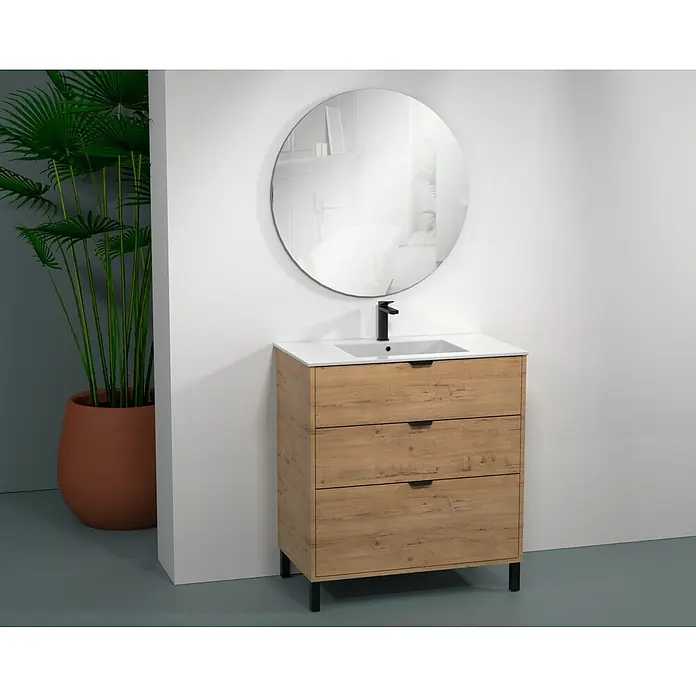 Conjunto de mueble de baño Triana - Ancho total del mueble de baño: 60 cm, Roble - La imagen muestra un mueble de baño con aspecto de madera con tres cajones, un lavabo de encimera blanco y un espejo redondo.