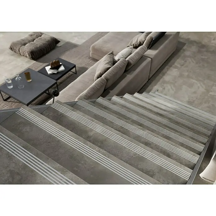 Queens Stufen- & Abdeckplatte - 29,8 x 119,8 cm, Grau, Matt - Dieses Bild zeigt eine elegante Treppe mit grauen Fliesenstufen und rutschfesten Streifen, die ein modernes Wohnambiente ergänzt.