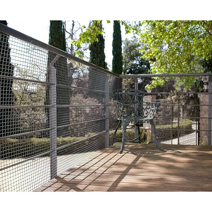 Nortene Malla protectora Cuadranet 11 - Gris, L x Al: 5 x 1 m - Mobiliario de jardín: una silla decorativa de metal se encuentra en una cubierta de madera con barandilla metálica, ofreciendo una vista panorámica.