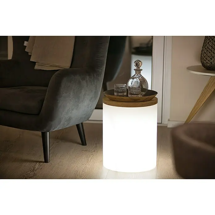 8 Seasons Design Shining Dekoleuchte Drum - 9 W, Weiß, L x B x H: 37 x 37 x 45 cm - Ein heller Leuchttisch mit Holzplatte, auf dem ein Getränkeset steht, neben einem eleganten Sessel.