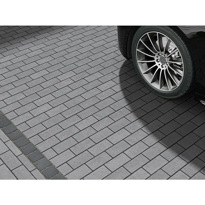 EHL Pflasterstein Drän - Anthrazit, 20 x 10 x 8 cm, Rechteckig - Nahaufnahme eines schwarzen Autos auf einem Pflasterweg, das hochwertige Pflastersteine zeigt, die für eine robuste und stilvolle Oberfläche sorgen.