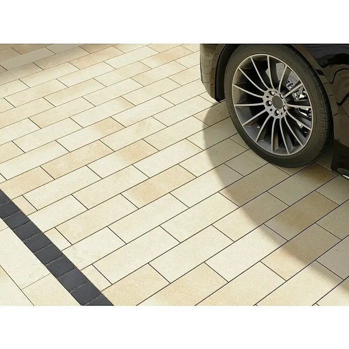 EHL Pflasterstein Cala KlassikSandstein nuanciert, 40 x 16 x 6 cm, Rechteckig - Pflastersteine in einem hellen Farbton mit einem dunklen Rand, der einen eleganten Übergang schafft, kombiniert mit einem stilvollen Auto.