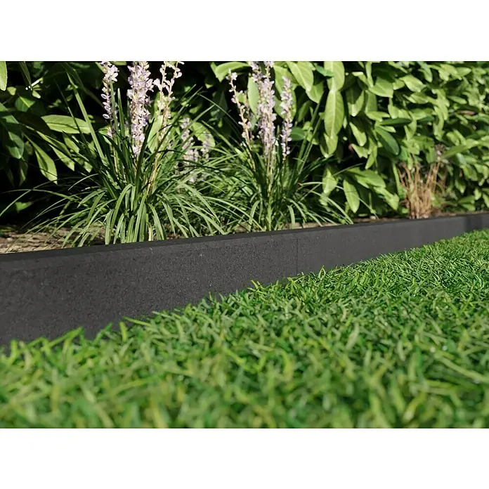 EHL Rasenkante C - 100 x 6 x 25 cm, Anthrazit, Beton - Nahaufnahme einer Rasenkante aus recyceltem Kunststoff, die einen grünen Rasen von Blumenbeeten trennt und eine saubere Abgrenzung im Garten schafft.