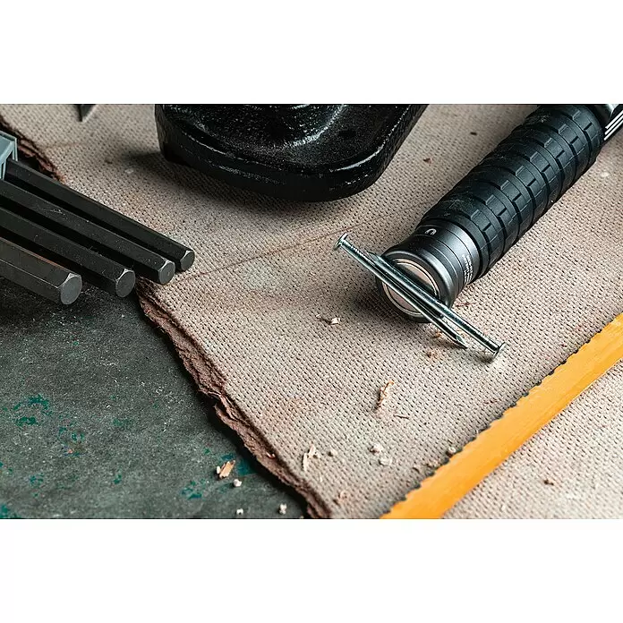 Nebo Tools Linterna Big Larry Pro+ - IPX7 - Herramienta de recogida magnética negra con mango de goma, que atrae clavos plateados, sobre una superficie de trabajo entre llaves Allen.