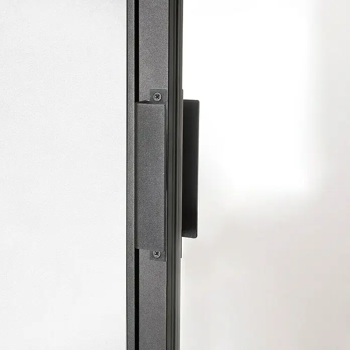 Kit atelier Drehtür Loft District880 x 2.005 mm, Links, Einscheibensicherheitsglas (ESG) - Nahaufnahme eines modernen Türgriffs aus Metall. Der Griff ist an einer grauen Tür befestigt und zeichnet sich durch ein schlichtes Design aus.