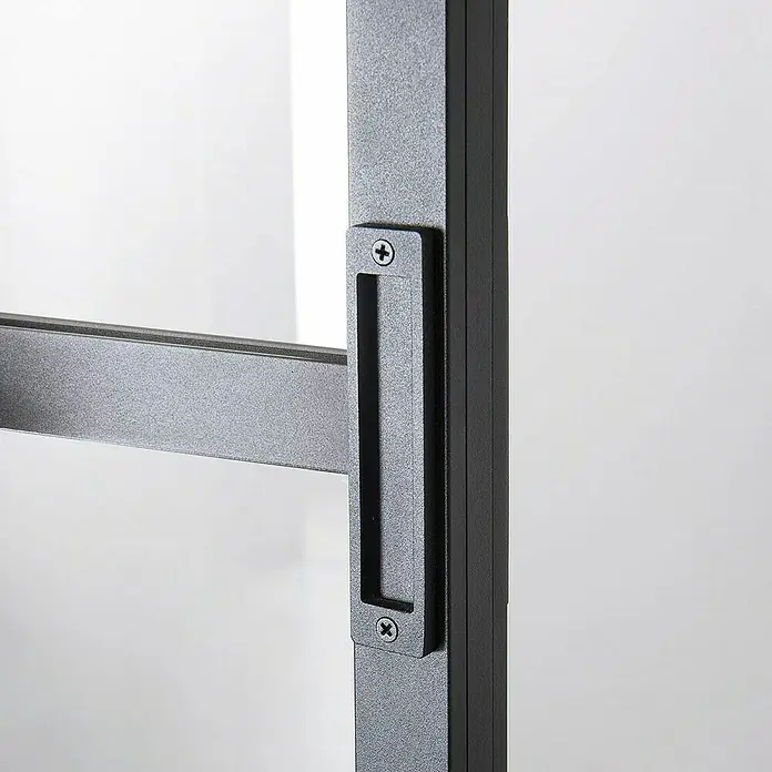 Kit atelier Glasschiebetür Loft Architekt - 930 x 2.128 mm, Einscheibensicherheitsglas (ESG) - Nahaufnahme eines schwarzen Türgriffs mit Schrauben an einer modernen Glastür, der das elegante Design und die hochwertige Verarbeitung hervorhebt.
