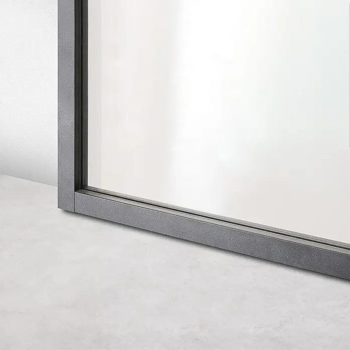 Kit atelier Drehtür Loft Architekt - 880 x 2.005 mm, Rechts, Einscheibensicherheitsglas (ESG) - Nahaufnahme eines modernen Fensters mit grauem Rahmen, das Design und Qualität vereint.\n