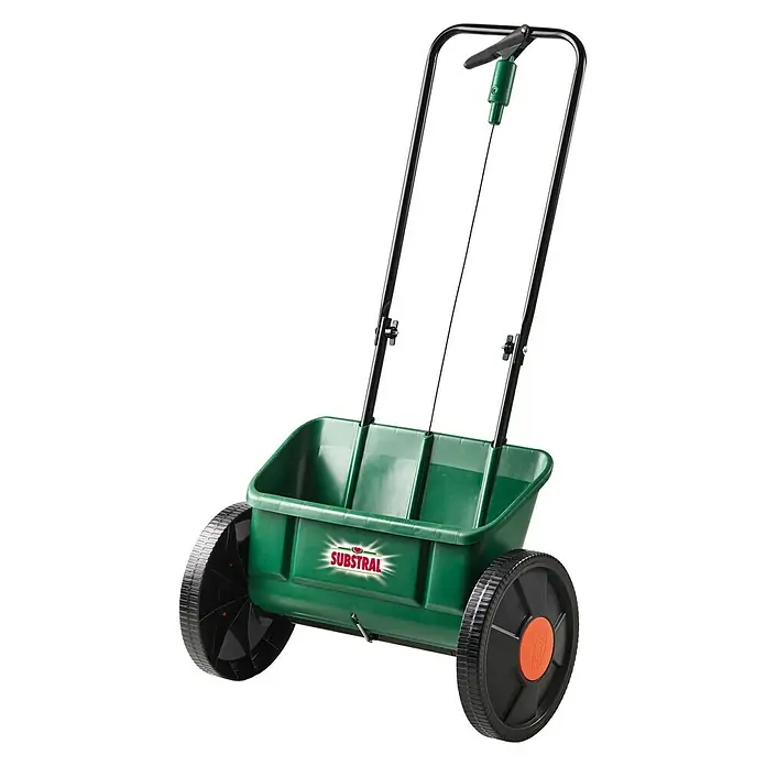 Substral Streuwagen EvergreenStreubreite: 45 cm, 11 l - Ein grüner Substral Streuwagen mit schwarzem Griff und Rädern, der für die Gartenarbeit verwendet wird.