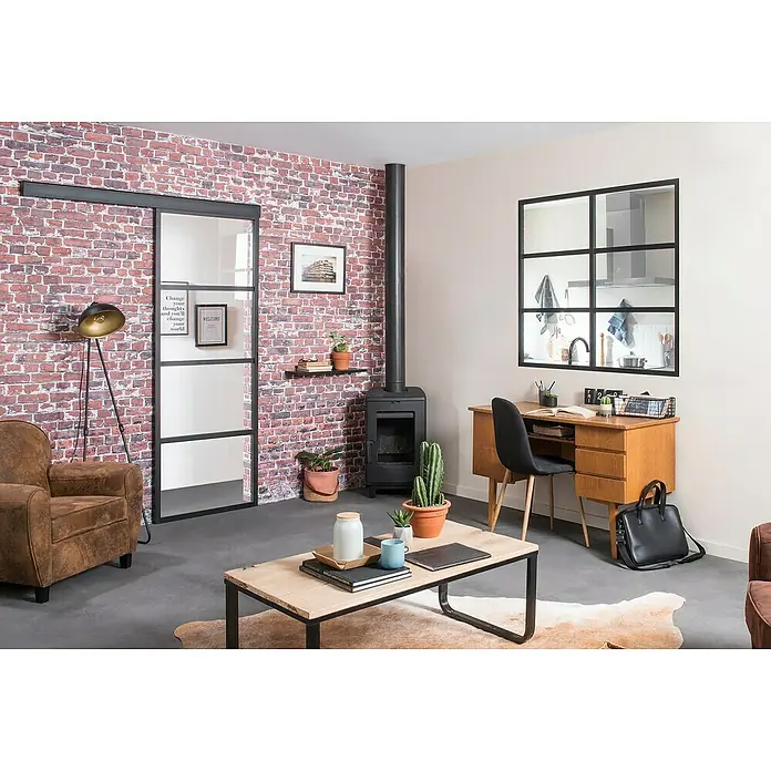 Kit atelier Glastrennwand Loft District - 1.232 x 1.200 mm, Einscheibensicherheitsglas (ESG) - Das Wohnzimmer verfügt über einen eleganten Tisch mit einem robusten schwarzen Metallgestell und einer hellen Holzplatte.