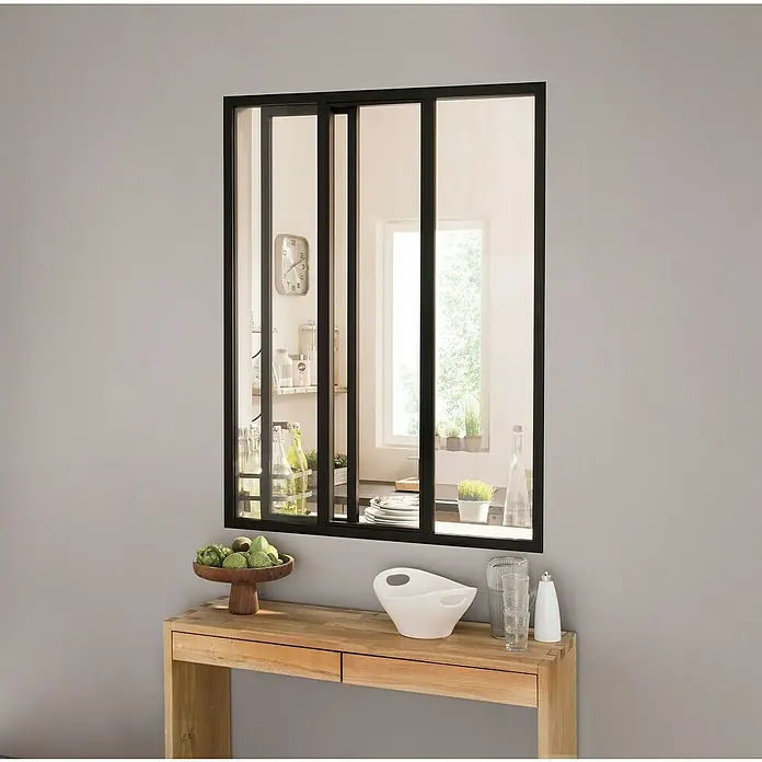 Kit atelier Glastrennwand Loft Atelier mit Schiebefenster - 932 x 1.300 mm, Einscheibensicherheitsglas (ESG) - Ein stilvolles Interieur mit einem schwarzen Fenster mit mehreren Glasscheiben über einer Holzkonsole mit Deko-Elementen.