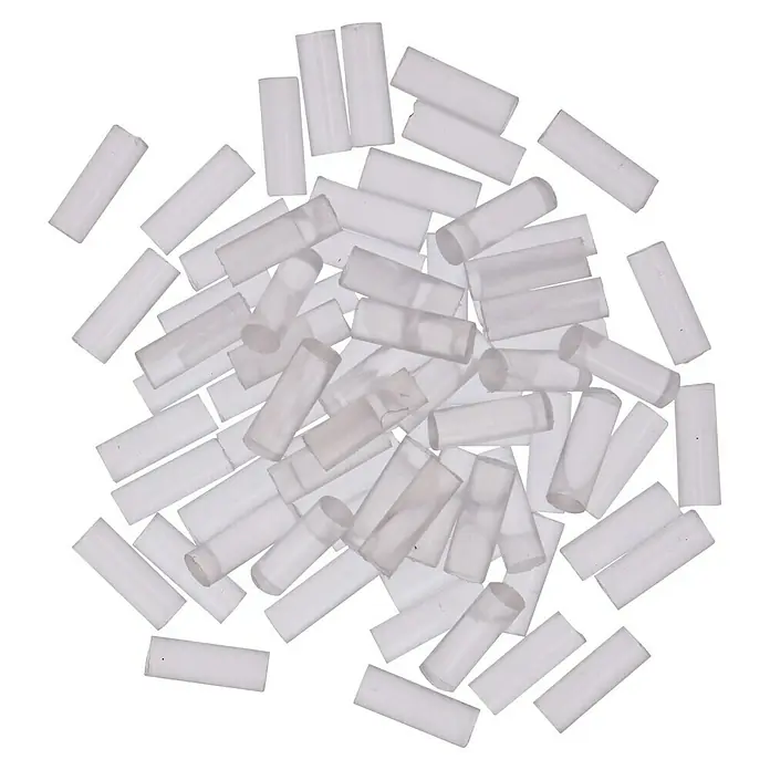Bosch Gluey Klebepatronen Transparent - 70 Stk., Durchmesser Klebepatrone: 7 mm, Transparent - Nahaufnahme von vielen kleinen, weißen Kunststoffhülsen, die auf einer schwarzen Oberfläche verteilt sind und für elektrische Verbindungen verwendet werden.