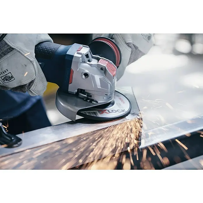 Bosch Disco de desbaste Expert for Metal A 30 T BF - Ø x Es: 125 x 6 mm, Orificio: 22,23 mm - Primer plano de una amoladora angular en acción, saltan chispas al esmerilar metal. Se usan guantes de seguridad para protección durante la operación.
