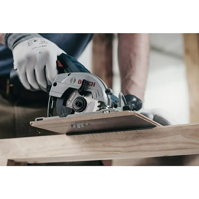 Bosch Kreissägeblatt Standard for Multimaterial - 85 mm, Bohrung: 15 mm, Anzahl Zähne: 30 Stk. - Bosch Akku-Handkreissäge schneidet Holz. Die Säge ist silbern und blau, mit dem Bosch-Logo gut sichtbar. Präzision und Leistung in Aktion.