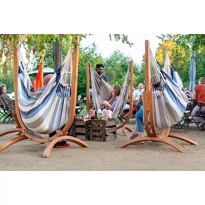 La Siesta Hängematten-Set Udine - L x B x H: 180 x 115 x 163 cm, Grau/Blau/Beige - Menschen entspannen in gestreiften und beigen Stoffhängematten auf Holzständern im Freien.