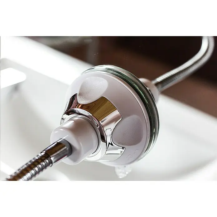 Deblanch Espejo cosmético orientable - 20 x 29,5 cm, Redonda, Blanco, Aumento 1: 300 %, Aumento 2: 700 % - Primer plano de un filtro de agua para cabezal de ducha, con detalles cromados y una manguera flexible sobre un lavabo blanco.