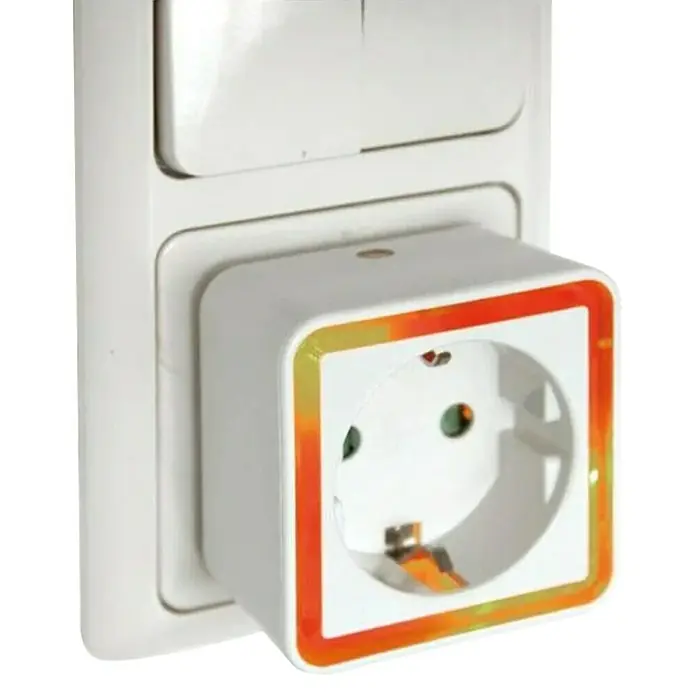 REV LED-Nachtlicht - Weiß, 56 x 54 x 55 mm, Steckdose - Ein weißer Adapter mit farbigem Rand steckt in einer Steckdose. Praktisch für Reisen und den täglichen Gebrauch, um Geräte anzuschließen.