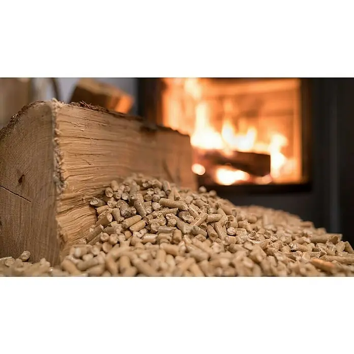 Pellets de madera Ecoloma - 1 ud., 15 kg - Primer plano de pellets de madera contra un tronco y una chimenea encendida, perfecto para un calor acogedor y un ambiente cómodo.
