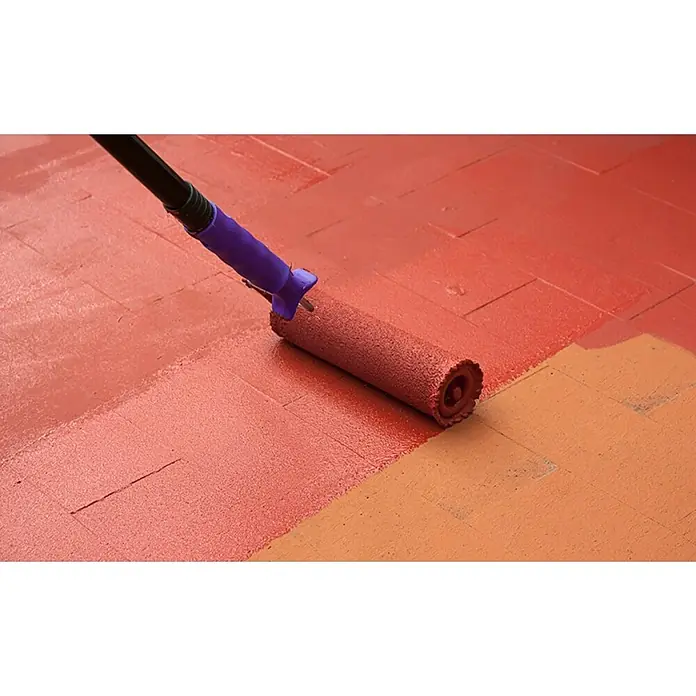 Kerakoll Impermeabilizante Bioscud - Rojo, 5 kg - Primer plano de un rodillo de pintura aplicando pintura roja a un patio de ladrillos, transformando los ladrillos en un rico color rojo.