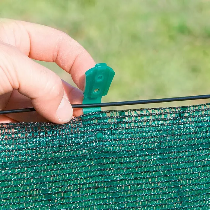 Nortene Clips Fixatex - 20 ud., Largo: 6,8 cm, Plástico - Primer plano de un clip de sujeción verde que sujeta una red verde a un alambre.