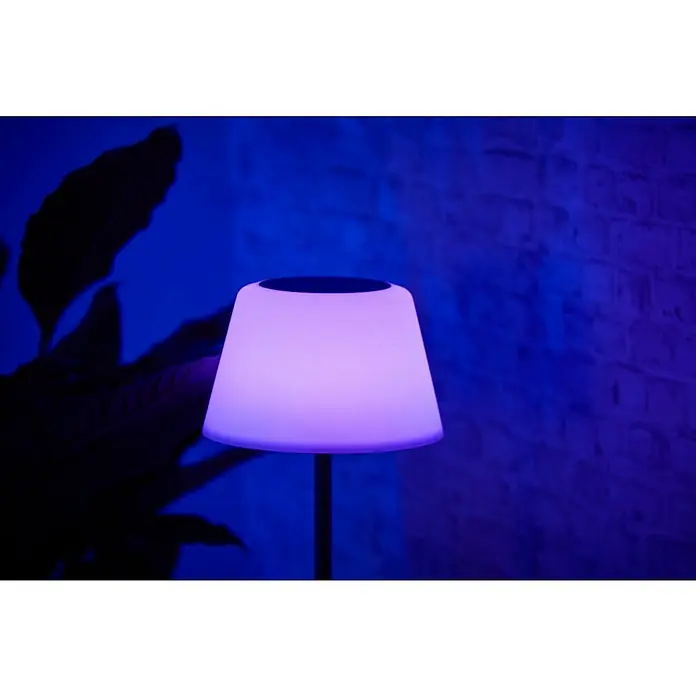BAUHAUS Solar-Stehleuchte - 5,8 W, L x B x H: 27,5 x 27,5 x 105,5 cm, Schwarz/Weiß, IP44 - Nahaufnahme einer stilvollen, beleuchteten Lampe mit lila Farbton vor einer Backsteinmauer, die eine gemütliche und moderne Atmosphäre ausstrahlt.