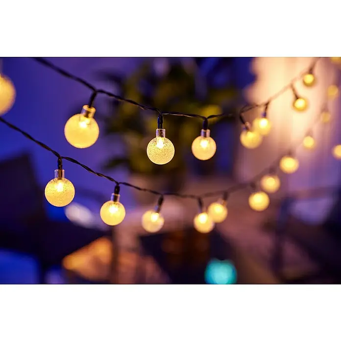 BAUHAUS LED-Solar-Lichterkette Balls - Außen, 6,9 m, Warmweiß - Nahaufnahme einer Lichterkette mit warm leuchtenden Kugeln, die eine gemütliche und festliche Atmosphäre erzeugen.