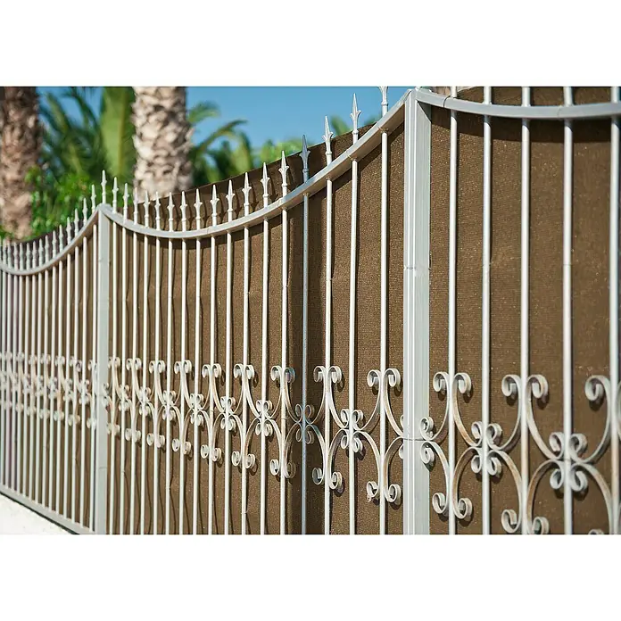 Faura Malla de ocultación 160 - 5 x 1 m, Marrón - Primer plano de una valla metálica decorativa con pantalla de privacidad marrón y elementos decorativos puntiagudos.