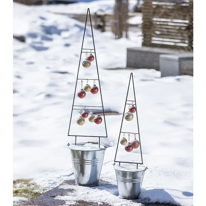 Windhager Rankhilfe Tree - B x H: 20 x 80 cm, Metall - Dekorative Metall-Weihnachtsbäume in silbernen Eimern mit glitzernden roten und goldenen Kugeln im verschneiten Außenbereich.